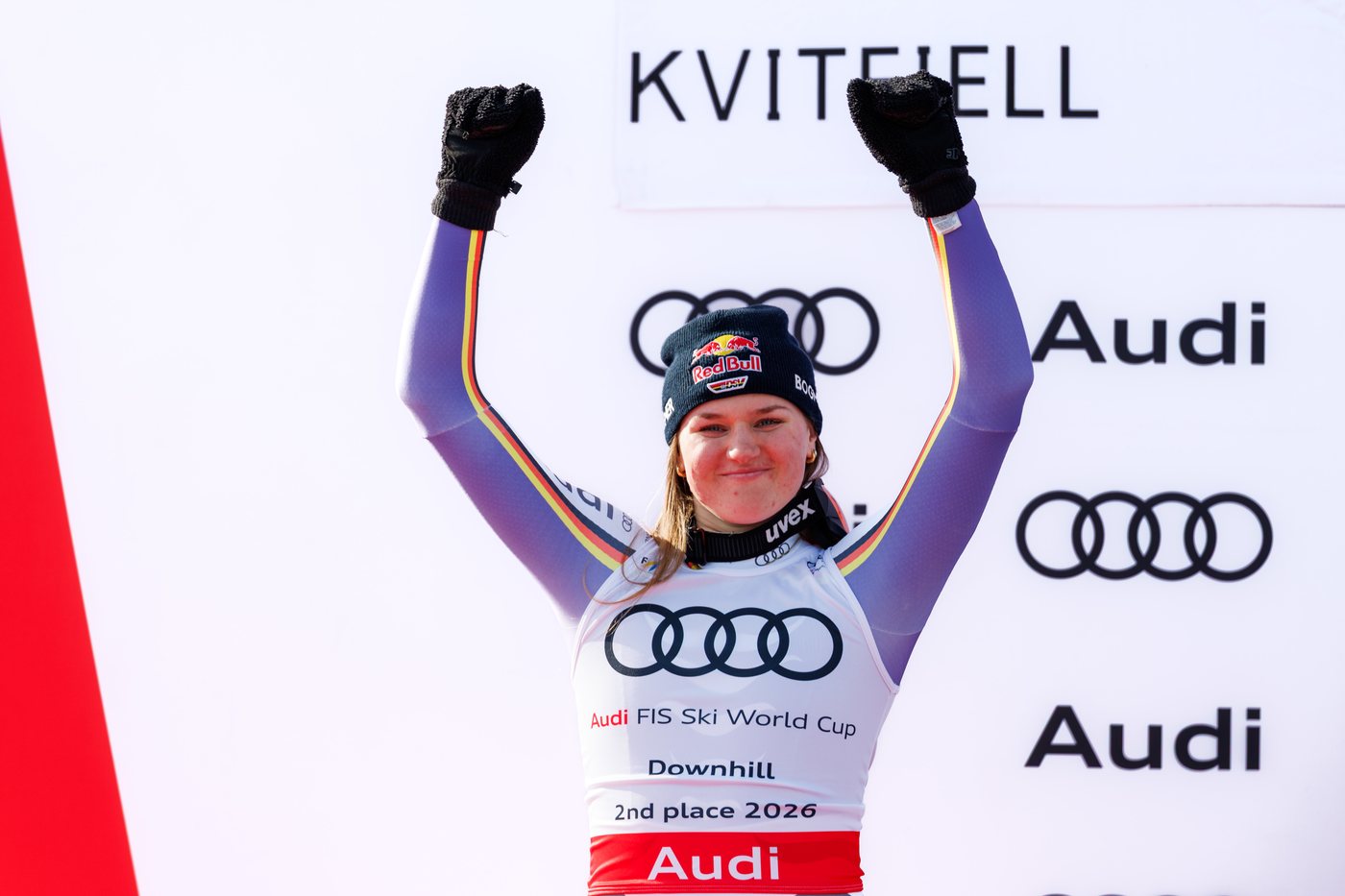 Emma Aicher z uniesionymi rękami na podium klasyfikacji zjazdu w Kvitfjell